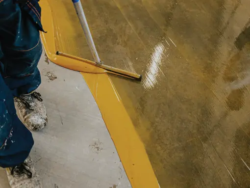 worker applying epoxy using flat brush